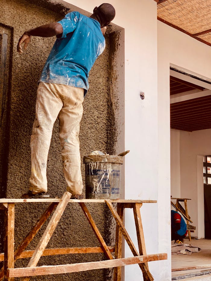 Home Hardworking construction worker plastering a wall in Kaduna, Nigeria.
