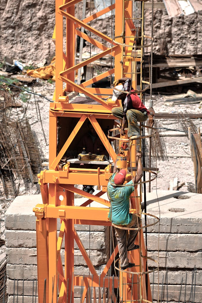 Home Workers climbing a construction tower in Fès, showcasing teamwork and safety.